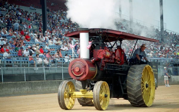 4K Ultra HD image of a vintage steam-powered tractor in motion at a crowded outdoor event, captured with clear detail and vibrant colors.