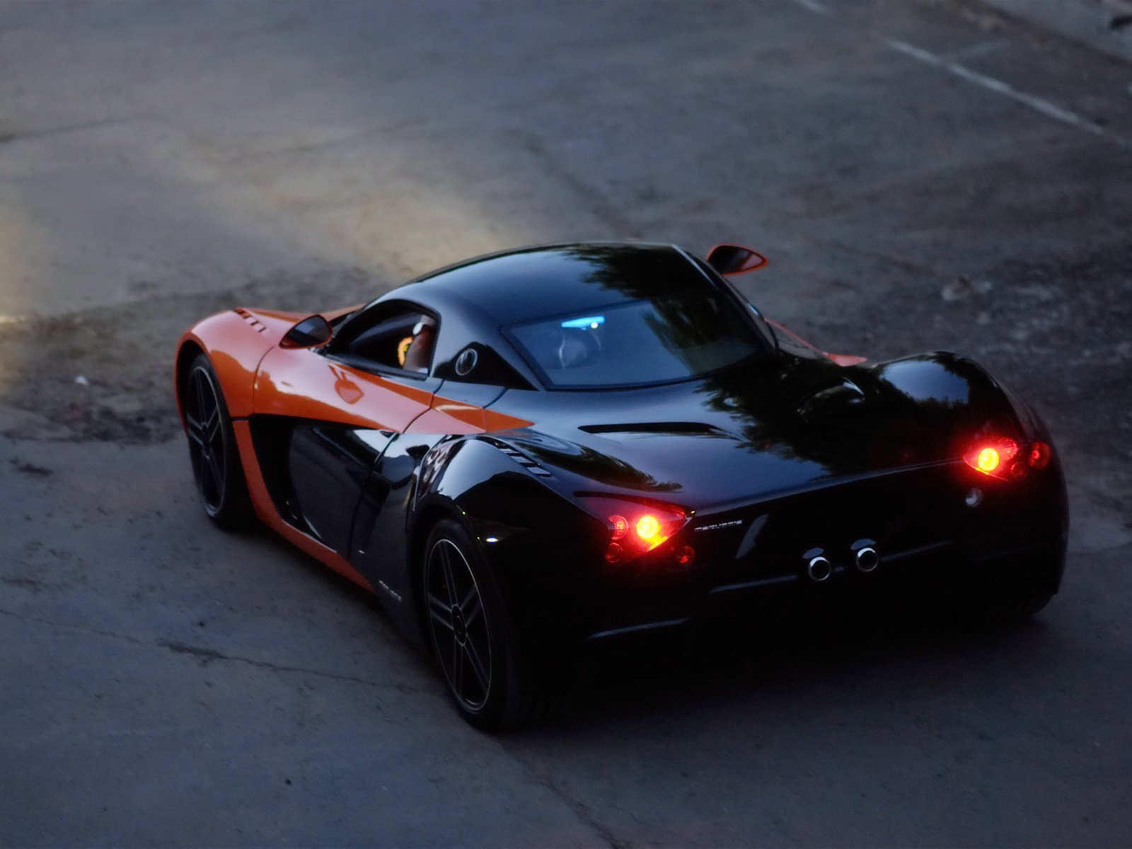 HD PC desktop wallpaper and background: rear three-quarter view of a black-and-orange Marussia sports car on asphalt at dusk, taillights glowing.