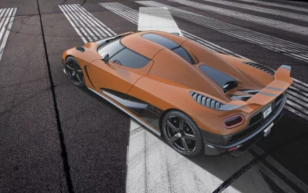A striking Koenigsegg Agera R parked on a sleek surface, showcasing its aerodynamic design and vibrant orange color. An eye-catching HD desktop wallpaper for automotive enthusiasts.