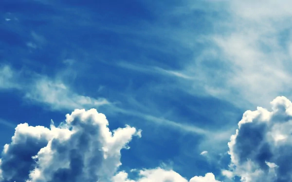 A serene sky filled with soft clouds against a vibrant blue backdrop, showcasing the beauty of nature in this HD desktop wallpaper.