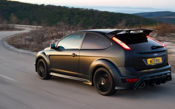 A matte black Ford Focus RS500 speeding on a winding mountain road, featured as an HD PC desktop wallpaper and background.