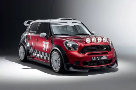HD PC desktop wallpaper: red Mini Cooper rally car (#37) with extra front lights and checkerboard livery on a neutral studio backdrop.