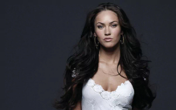 HD wallpaper of celebrity Megan Fox with dark, flowing hair, wearing a white lace dress against a dark background.
