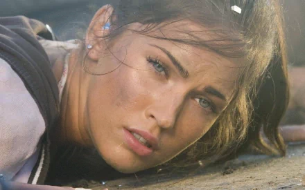 HD desktop wallpaper of Megan Fox from the movie Transformers, featuring a close-up of her face with a focused expression.