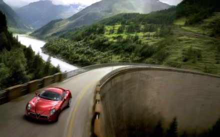 HD PC desktop wallpaper background: red Alfa Romeo 8C Competizione driving along a curved mountain dam road with river and green valleys under misty peaks.