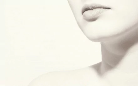 Close-up of a woman's sensual features, showcasing her lips and neck in a soft, minimalist style, designed as an HD desktop wallpaper and background.