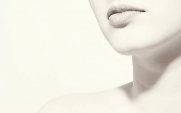Close-up of a woman's sensual features, showcasing her lips and neck in a soft, minimalist style, designed as an HD desktop wallpaper and background.