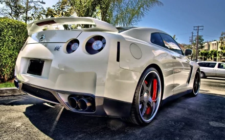 HD PC desktop wallpaper of a white Nissan GT‑R sports vehicle, rear three-quarter view parked in a sunlit lot.