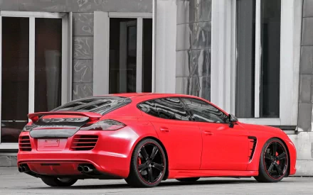 Red Porsche vehicle parked by a modern building — HD PC desktop wallpaper/background.