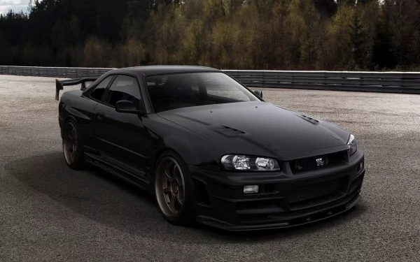 Black Nissan sports coupe on a racetrack with a wooded backdrop and moody lighting — HD PC desktop wallpaper and background.