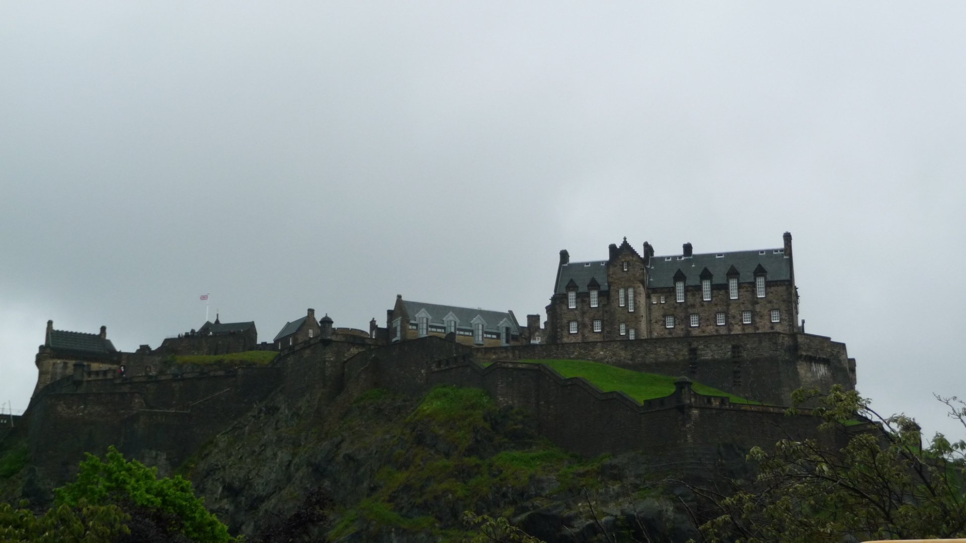 Edinburgh castle perched on a rocky crag under an overcast sky, a man-made stone fortress — HD PC desktop wallpaper background.
