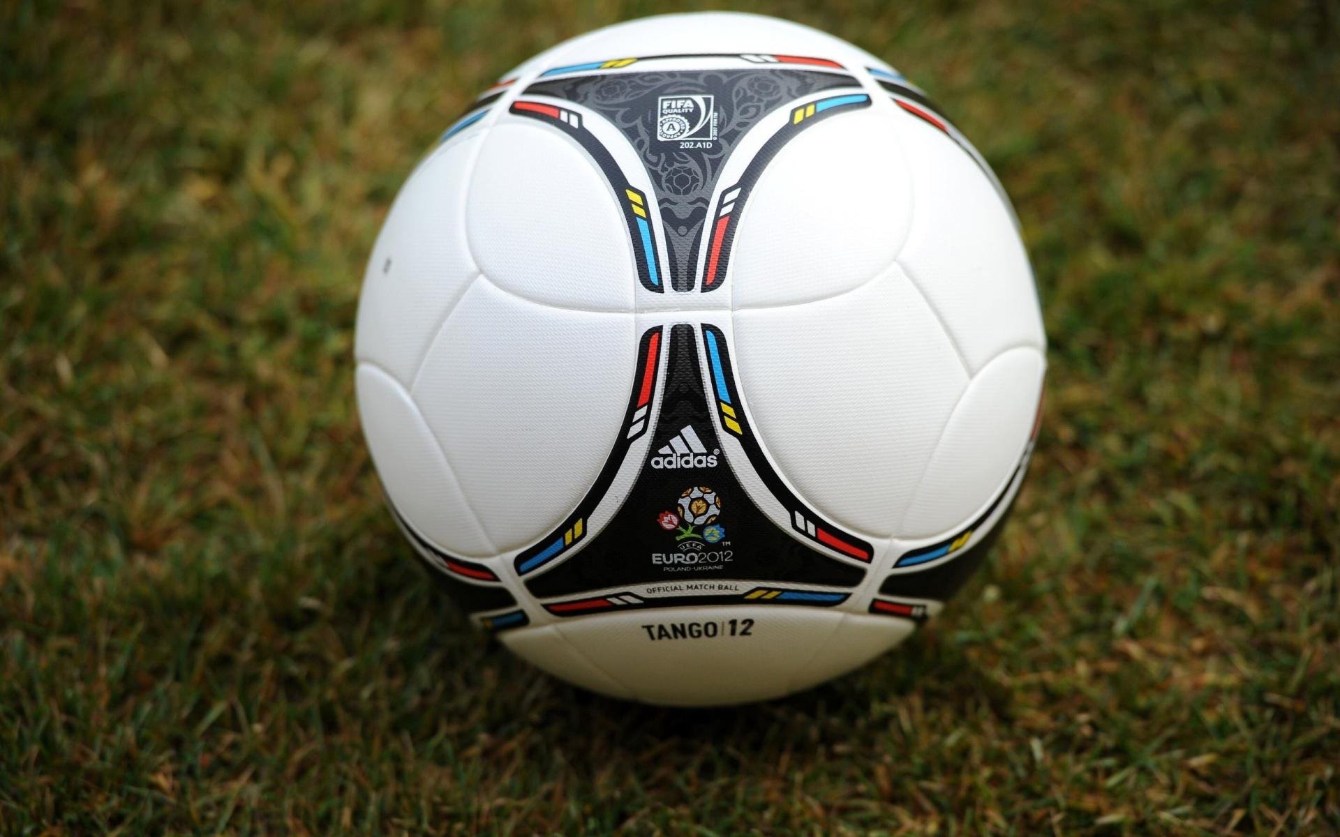 HD desktop wallpaper featuring a man-made Adidas Tango 12 soccer ball resting on grass.