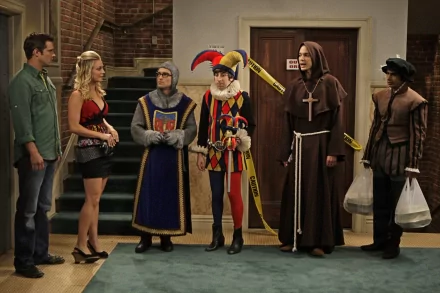 The Big Bang Theory cast, including Raj Koothrappali, Sheldon Cooper, Howard Wolowitz, Leonard Hofstadter, and Penny, dressed in costumes inside an apartment set.