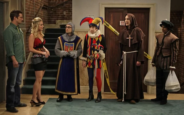 The Big Bang Theory cast, including Raj Koothrappali, Sheldon Cooper, Howard Wolowitz, Leonard Hofstadter, and Penny, dressed in costumes inside an apartment set.