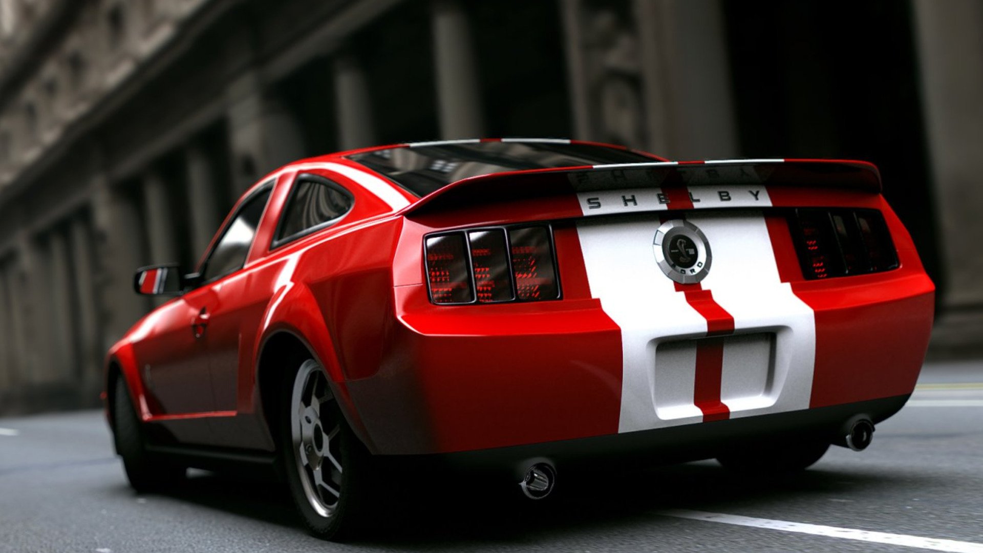 HD PC desktop wallpaper featuring a red Ford Mustang Shelby GT500 with white racing stripes, showcased from the rear on an urban street.