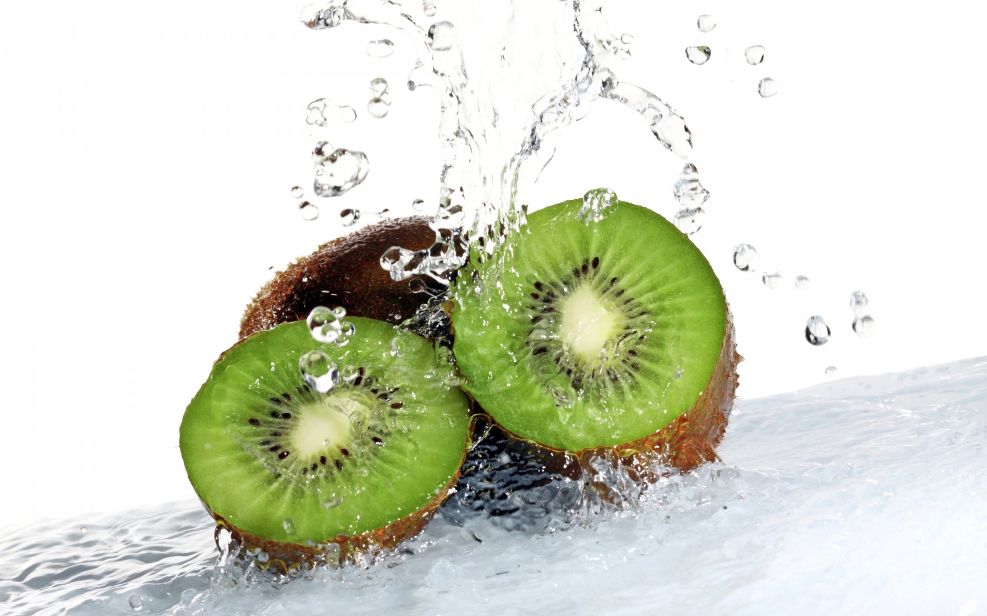 HD desktop wallpaper of fresh kiwi fruit splashing into clear water, highlighting vibrant green flesh and droplets against a white background.