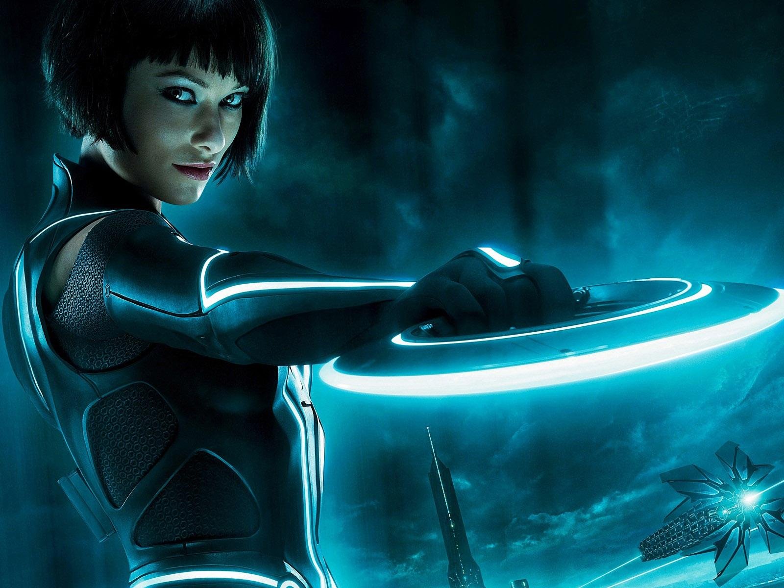 HD PC desktop wallpaper featuring a character from the movie TRON: Legacy holding a glowing disc in a futuristic, neon-lit environment.