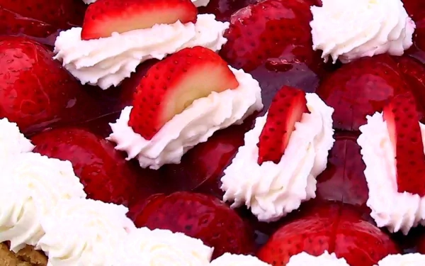 A vibrant HD desktop wallpaper featuring a delicious dessert topped with fresh strawberries and whipped cream, creating an inviting and appetizing visual.