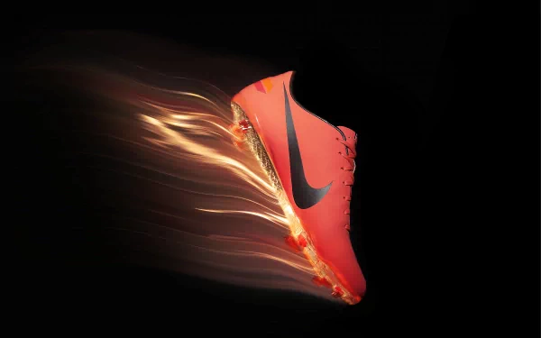 A dynamic HD desktop wallpaper featuring a vibrant Nike shoe, captured mid-motion with streaks of light, showcasing its man-made design and energetic appeal.