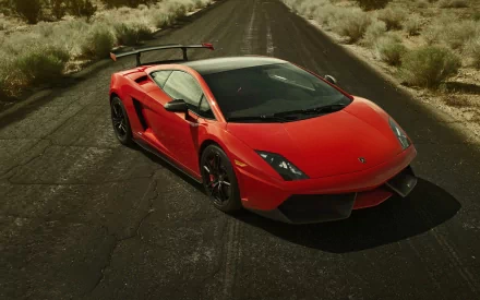 Red Lamborghini Gallardo sports vehicle on a cracked desert road, dramatic wide-angle shot — HD PC desktop wallpaper and background.