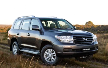 HD PC desktop wallpaper: Toyota vehicle (SUV) parked on a grassy plain, three-quarter front view with clear sky and scenic background.