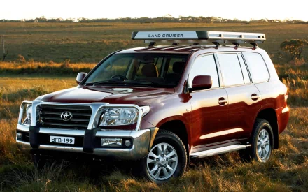 HD PC desktop wallpaper background featuring a red Toyota vehicle (SUV) parked on a grassy plain at sunset.
