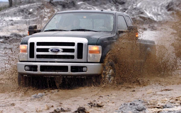 Ford Super Duty truck driving through muddy terrain, captured in an HD PC desktop wallpaper showcasing rugged off-road capability.
