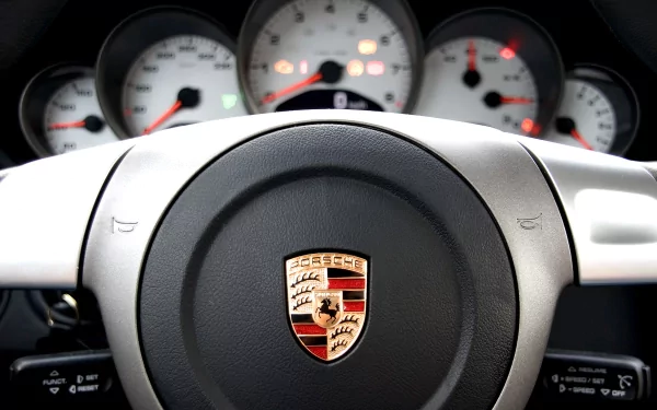 Close-up of a Porsche steering wheel and dashboard gauges, captured in high definition for a PC desktop wallpaper background.