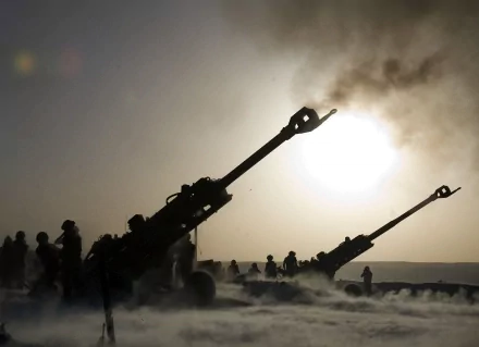 HD desktop wallpaper showing soldiers operating artillery guns amid smoky battlefield atmosphere.