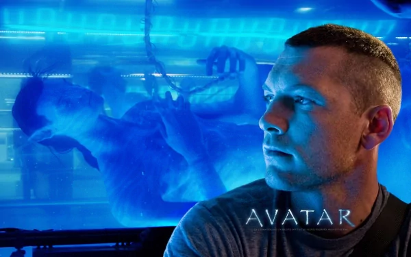 HD PC desktop wallpaper featuring Sam Worthington as Jake Sully from the movie Avatar, with a blue-toned futuristic background and the Avatar logo.