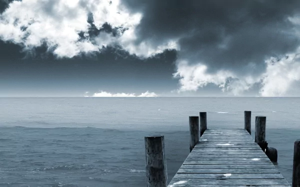 A serene HD desktop wallpaper featuring a man-made wooden pier extending over calm ocean waters, under a dramatic sky filled with clouds.