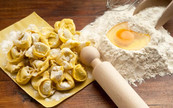 HD PC desktop wallpaper featuring fresh pasta and a heart-shaped cracked egg in flour on a wooden surface with a rolling pin.