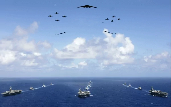 HD desktop wallpaper featuring a naval fleet with warships and military airplanes arrayed over the ocean under a partly cloudy sky.