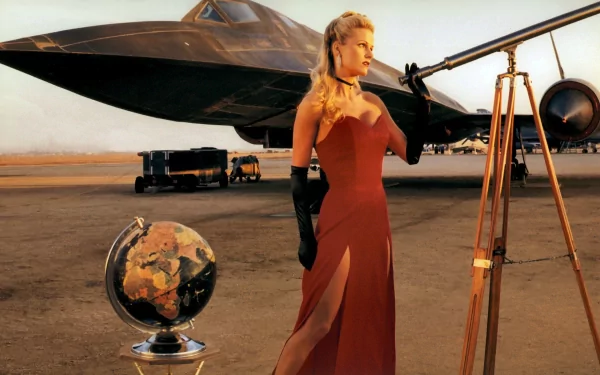 HD desktop wallpaper featuring a woman in a red dress standing beside a Lockheed SR-71 Blackbird aircraft, with a globe and a telescope on a desert airstrip.
