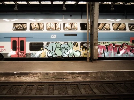 HD desktop wallpaper featuring a vibrant graffiti art on a train, tagged with hustla, artistic, and graffiti. The scene is set on a railway platform showcasing striking urban street art.
