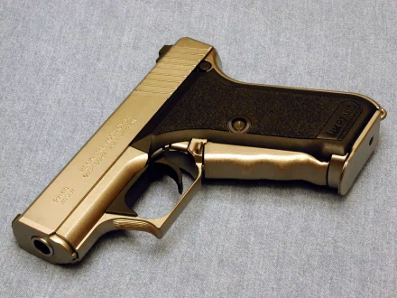 HD desktop wallpaper featuring a man-made Heckler & Koch pistol on a grey background.