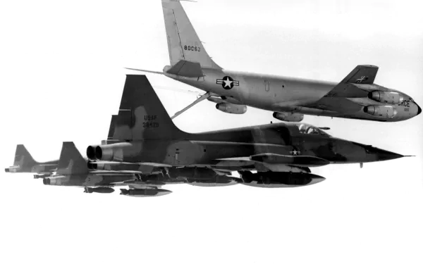 A striking HD wallpaper features Northrop F-5A/B Freedom Fighters alongside a KC-135, showcasing military aviation in dynamic formation.