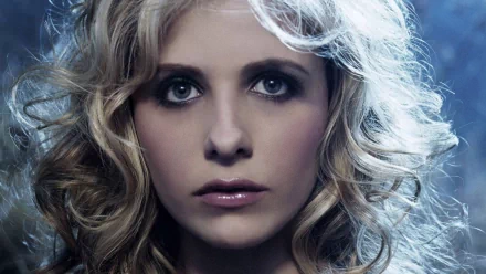 High-definition wallpaper featuring a close-up of celebrity Sarah Michelle Gellar with intense eyes and curly blonde hair against a dark background.