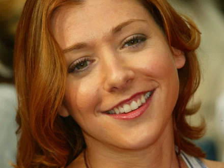 Alyson Hannigan smiles warmly, showcasing her red hair and inviting personality. This HD desktop wallpaper captures her charm, making it an engaging background choice.