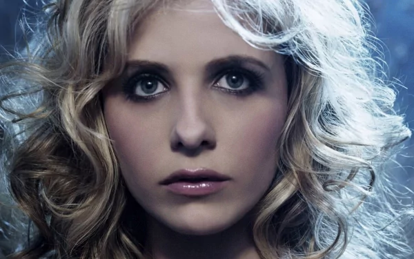 High-definition wallpaper featuring a close-up of celebrity Sarah Michelle Gellar with intense eyes and curly blonde hair against a dark background.