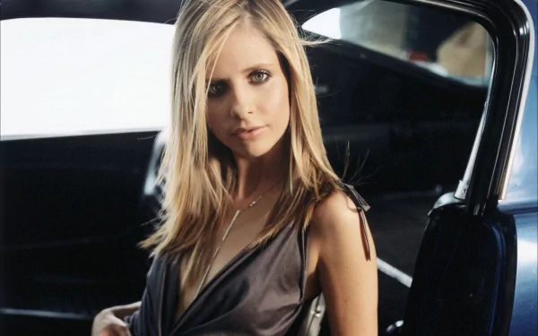 HD desktop wallpaper featuring celebrity Sarah Michelle Gellar seated in a car, exuding elegance with her blonde hair and deep neckline outfit.