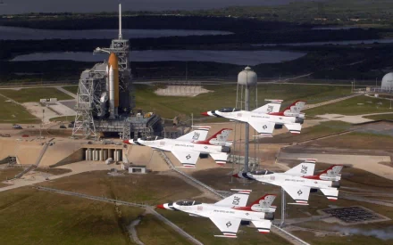 Four military jets fly in formation near a space shuttle launch site, captured in high definition for an air show-themed desktop wallpaper and background.