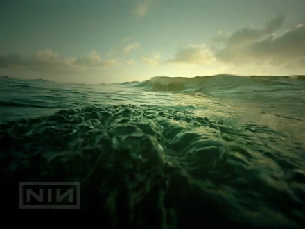 HD PC desktop wallpaper featuring a moody ocean scene with waves under a cloudy sky, branded with the Nine Inch Nails logo, blending music and atmospheric visuals.