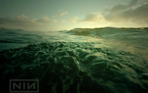 HD PC desktop wallpaper featuring a moody ocean scene with waves under a cloudy sky, branded with the Nine Inch Nails logo, blending music and atmospheric visuals.
