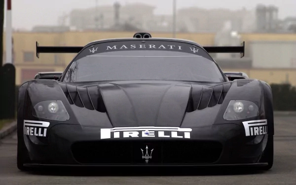 A sleek black Maserati racing vehicle, showcasing its aerodynamic design and bold branding, set against a muted background, creating an impressive HD desktop wallpaper.