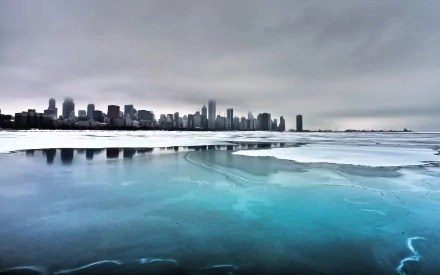 A stunning HD desktop wallpaper showcasing the Chicago skyline against a backdrop of icy waters and overcast skies, capturing the essence of urban beauty in winter.
