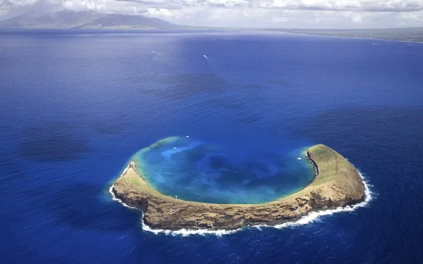 A stunning aerial view of a serene island surrounded by deep blue waters, showcasing the beauty of nature in this high-definition desktop wallpaper.