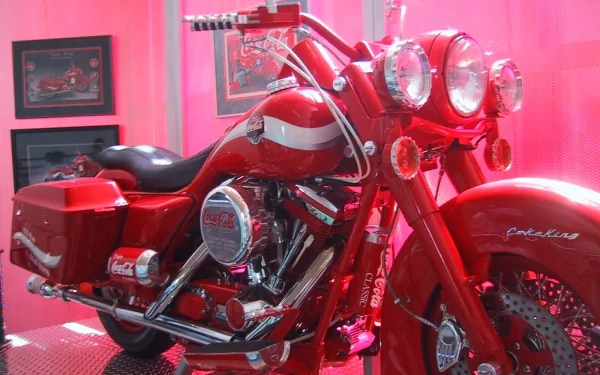 A striking red motorcycle with Coca-Cola branding, showcased against a vibrant pink background, serves as an eye-catching HD desktop wallpaper.