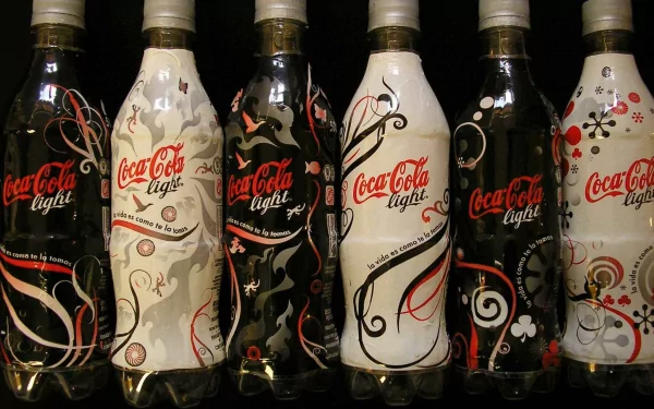 A collection of Coca Cola Light bottles featuring unique designs in black, white, and red, displayed side by side, creating an appealing man-made wallpaper for HD desktops.