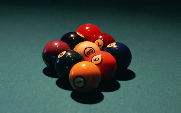 A close-up of billiard balls arranged in a triangle, set against a rich green felt background, creating an engaging HD desktop wallpaper for pool game enthusiasts.